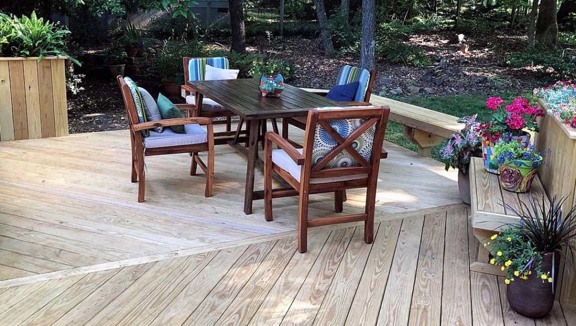 A table and chairs on a deck
Description automatically generated