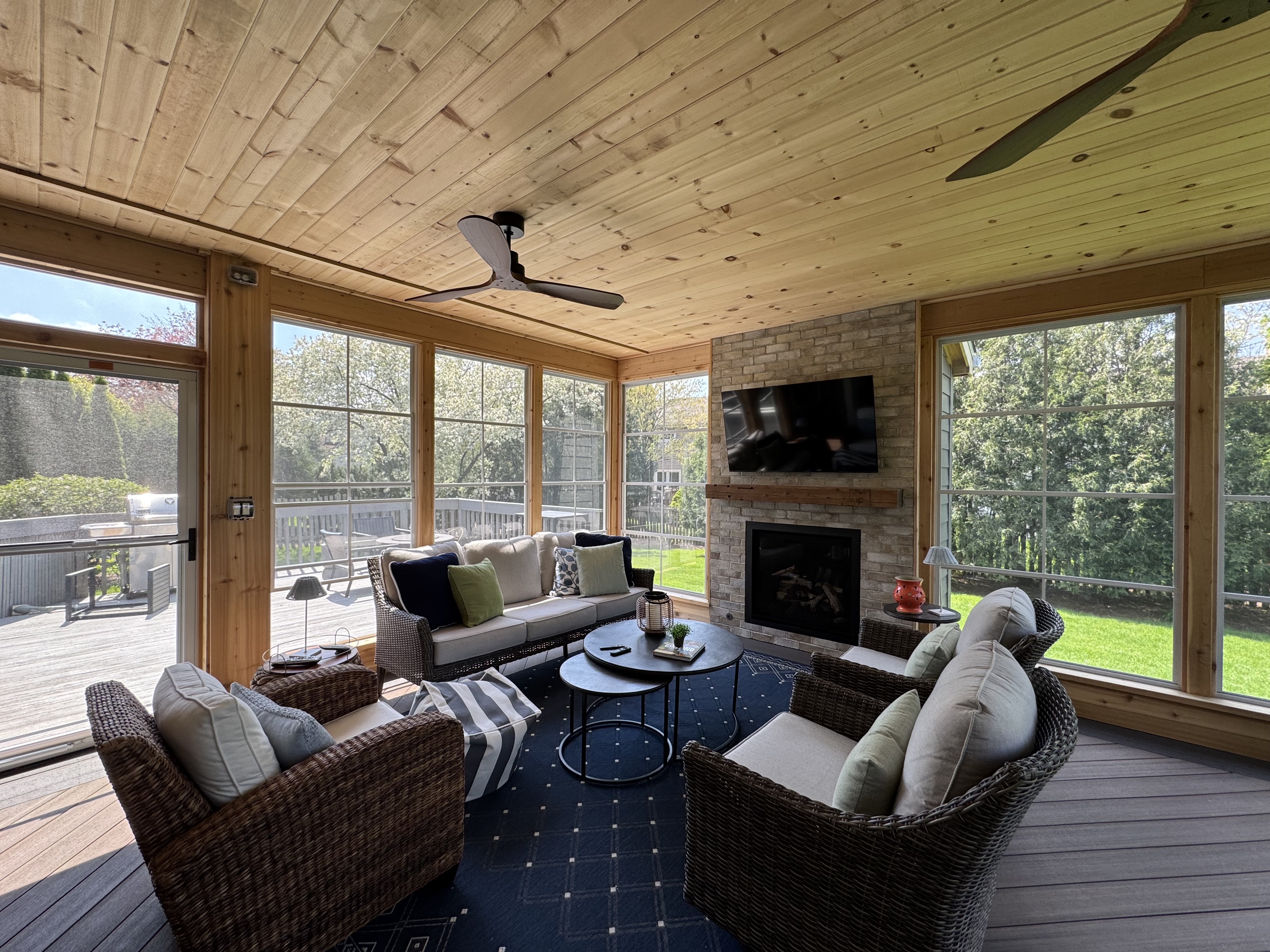 Inside of a 3-season room featuring 4-track windows and a custom fireplace by Archadeck of Naperville.