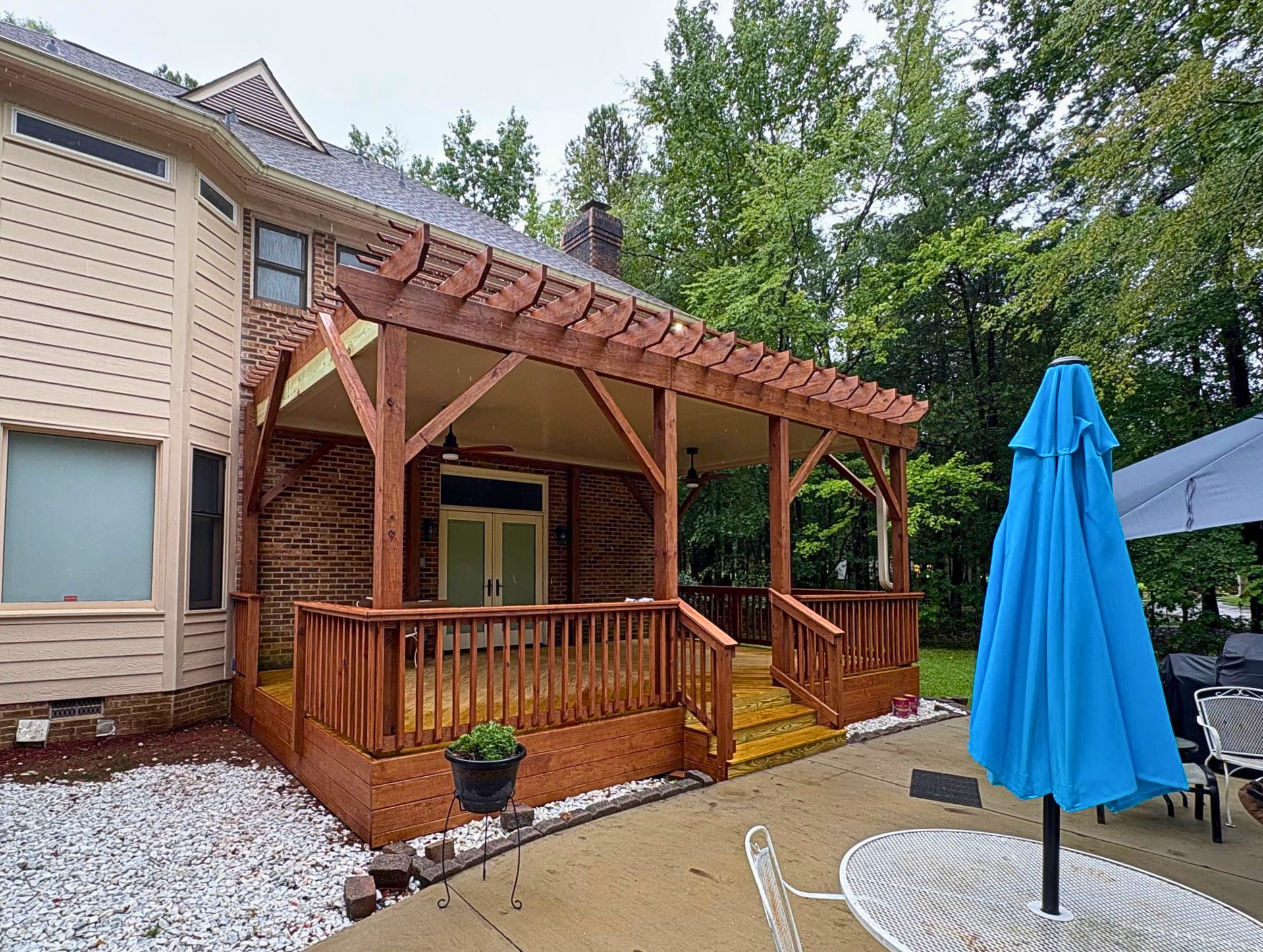 Custom pergola with underdeck roof and dark red stain in charlotte, NC.