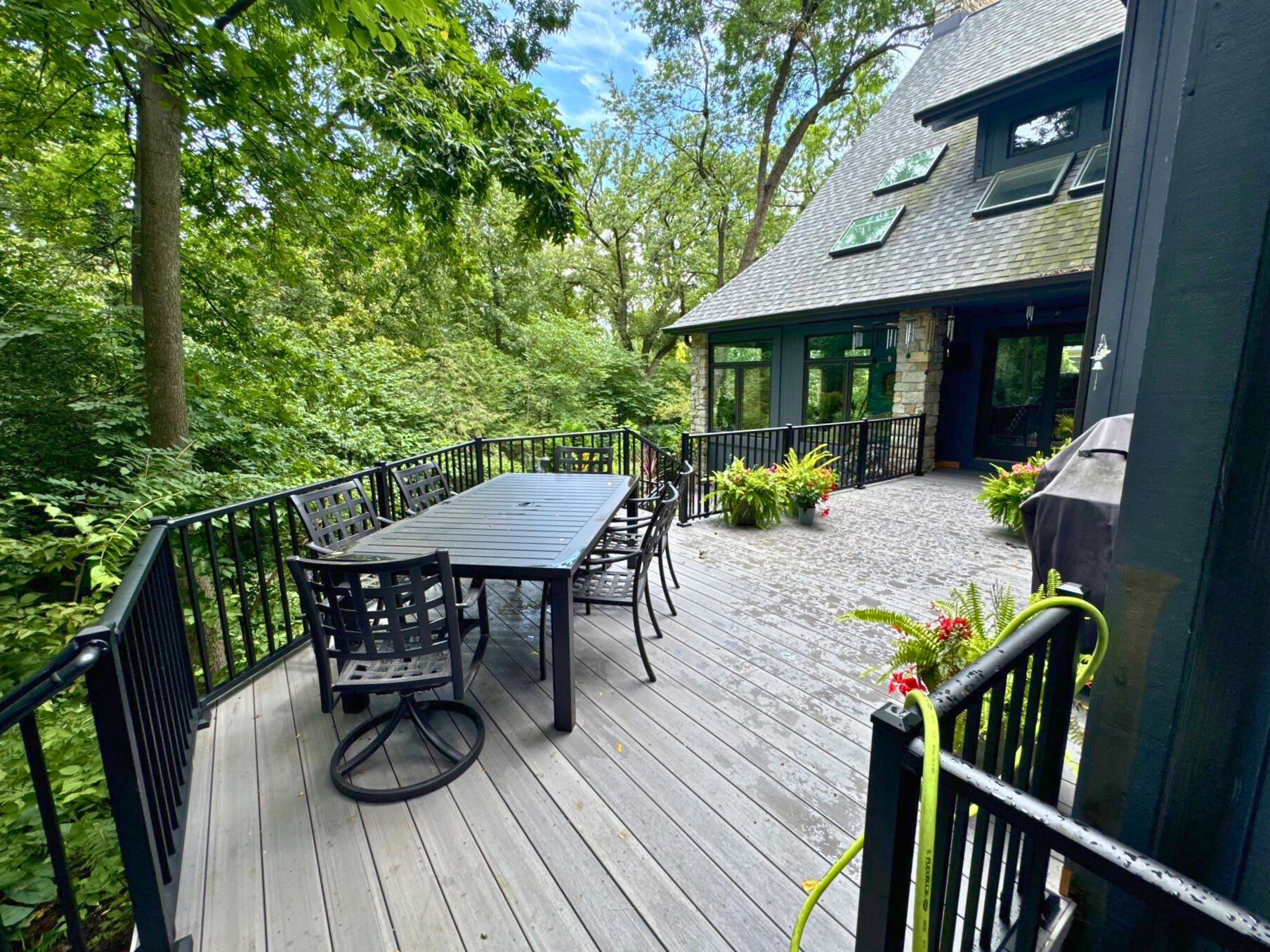 Elevated Grey TimberTech deck with black aluminum rails overlooking Lucious green trees in Lisle, IL.