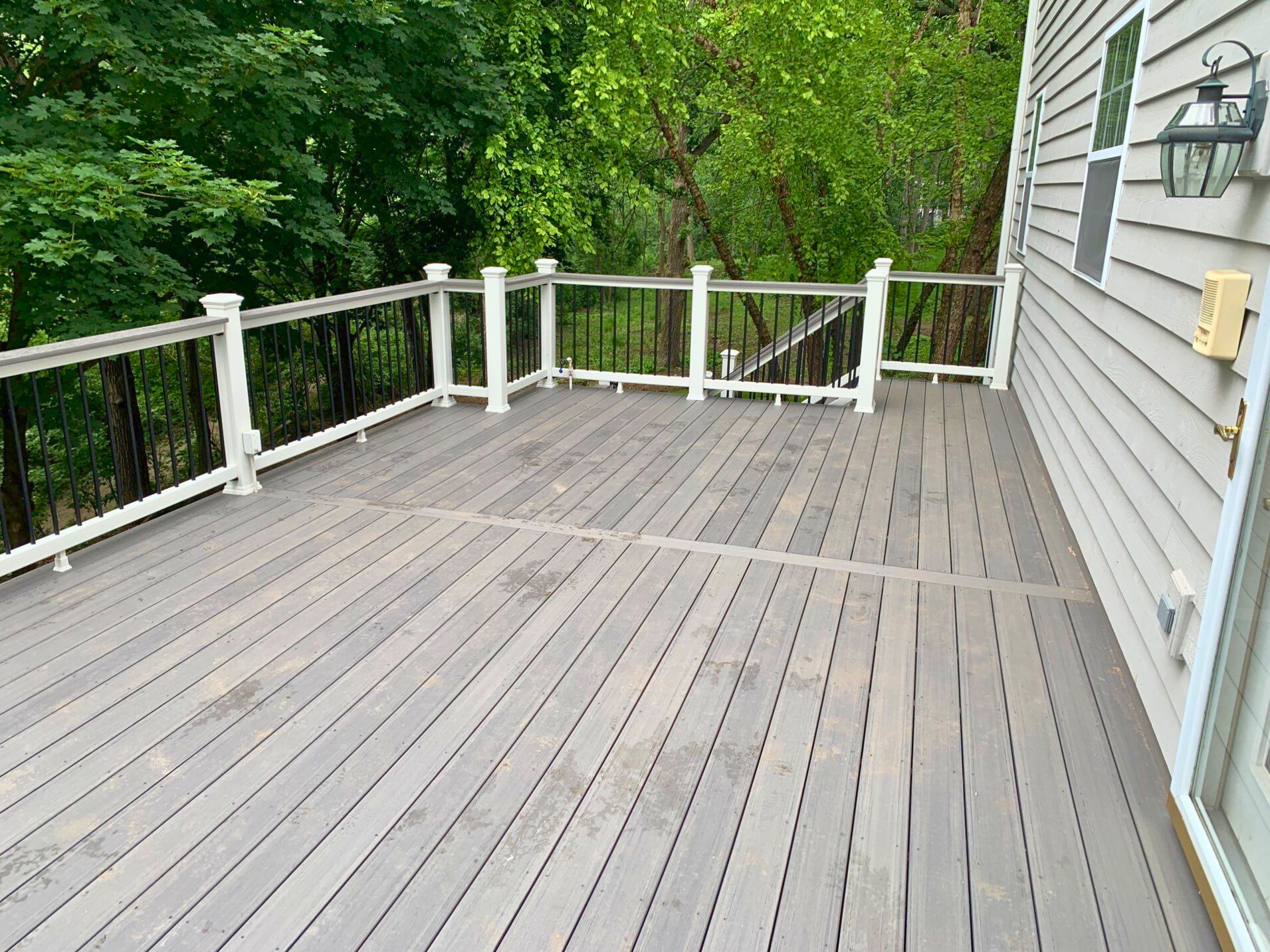 Grey TimberTech deck with white rails and black aluminum rails in Long Grove, IL backyard.