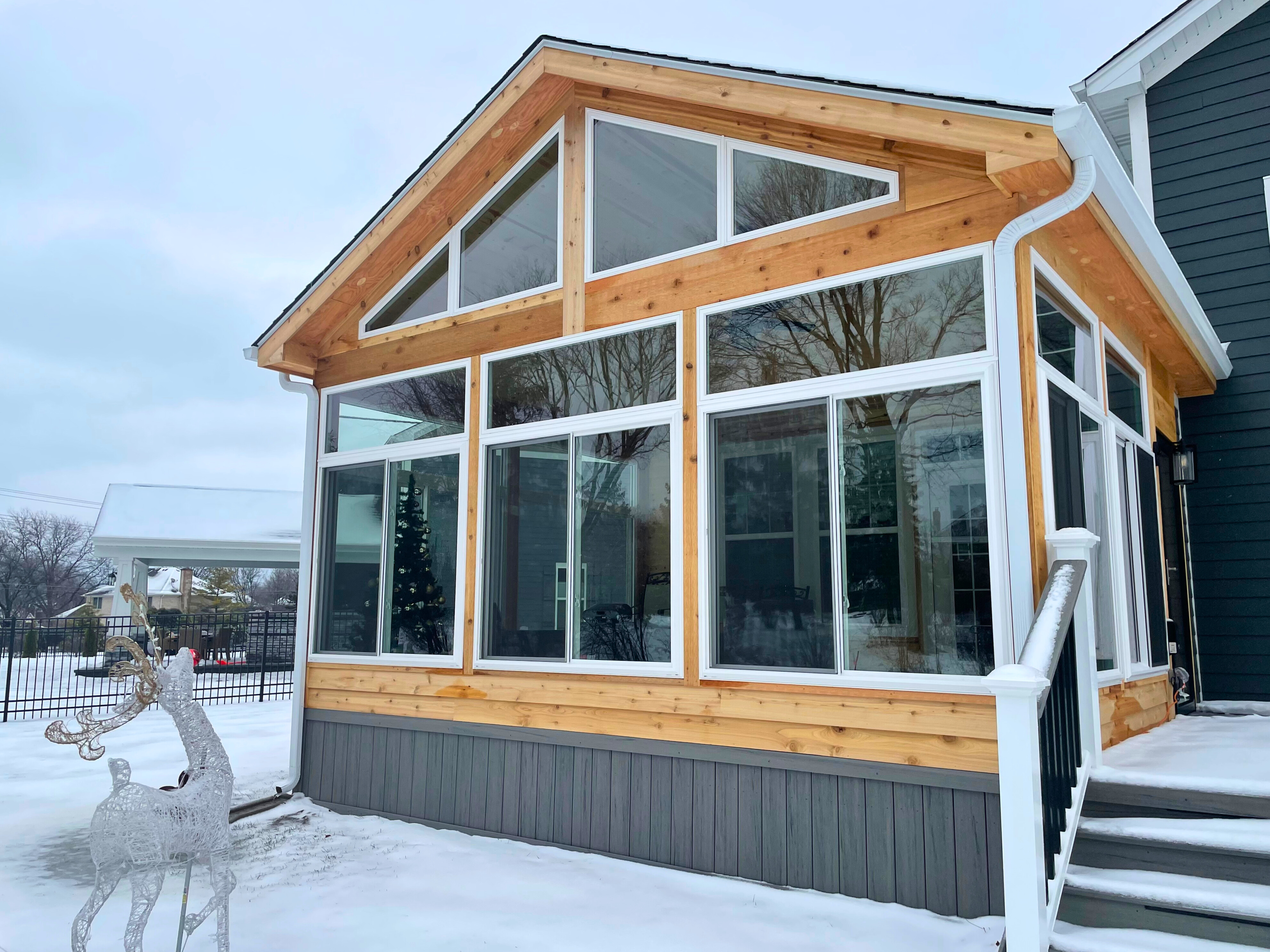 Outside of a custom sunroom with composite decking and glass windows in Naperville, IL.