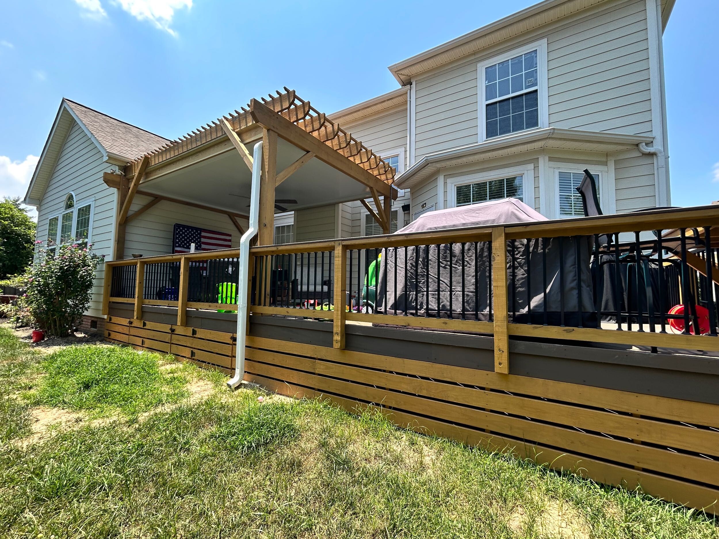 Composite deck with wood skirting and covered pergola in Lake Wylie, SC.