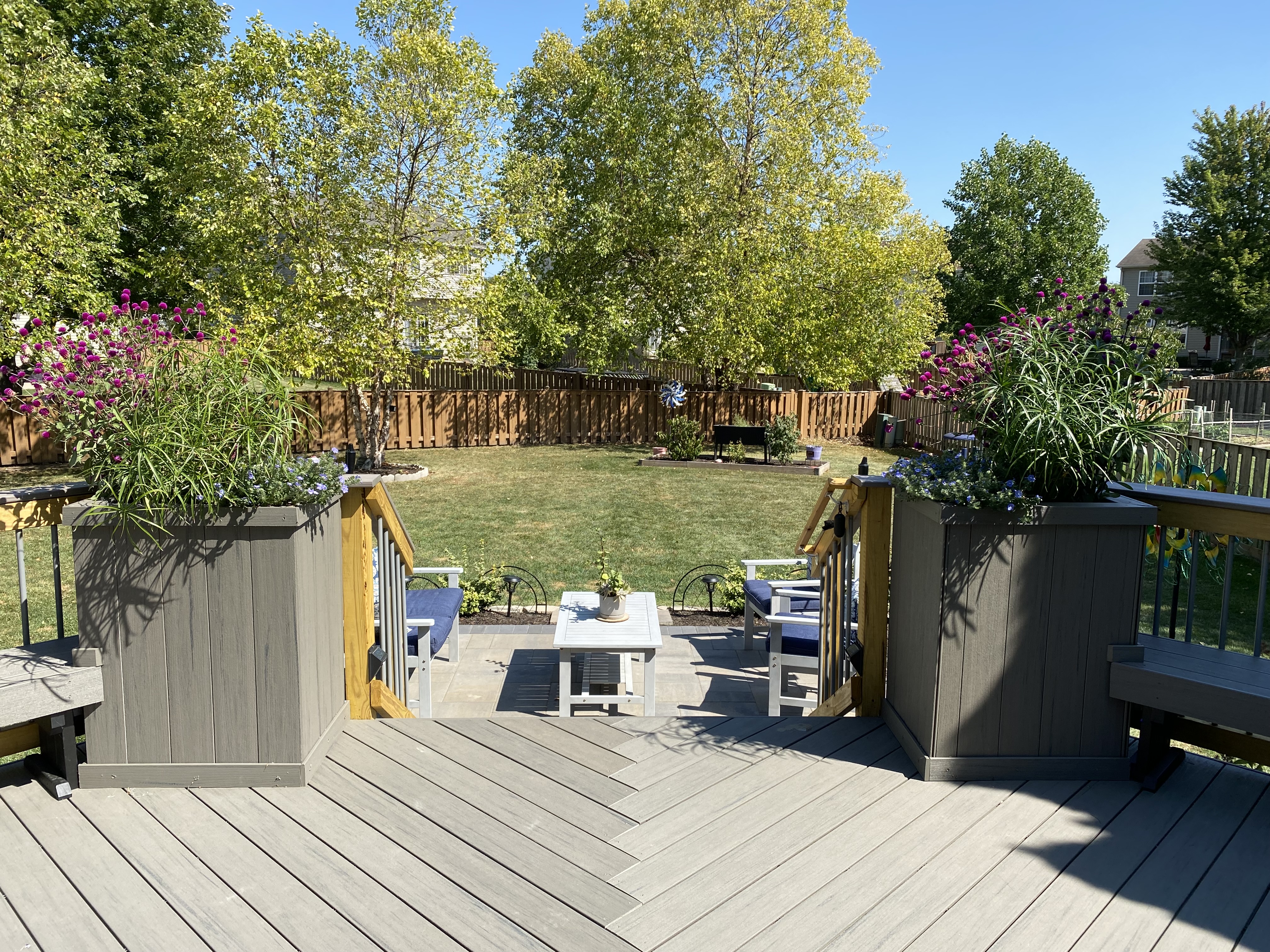 TimberTech deck with two planter beds overlooking a paver patio and backyard in Tinley Park, IL.