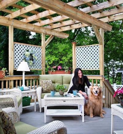 pergola with furniture, woman, and dog. 