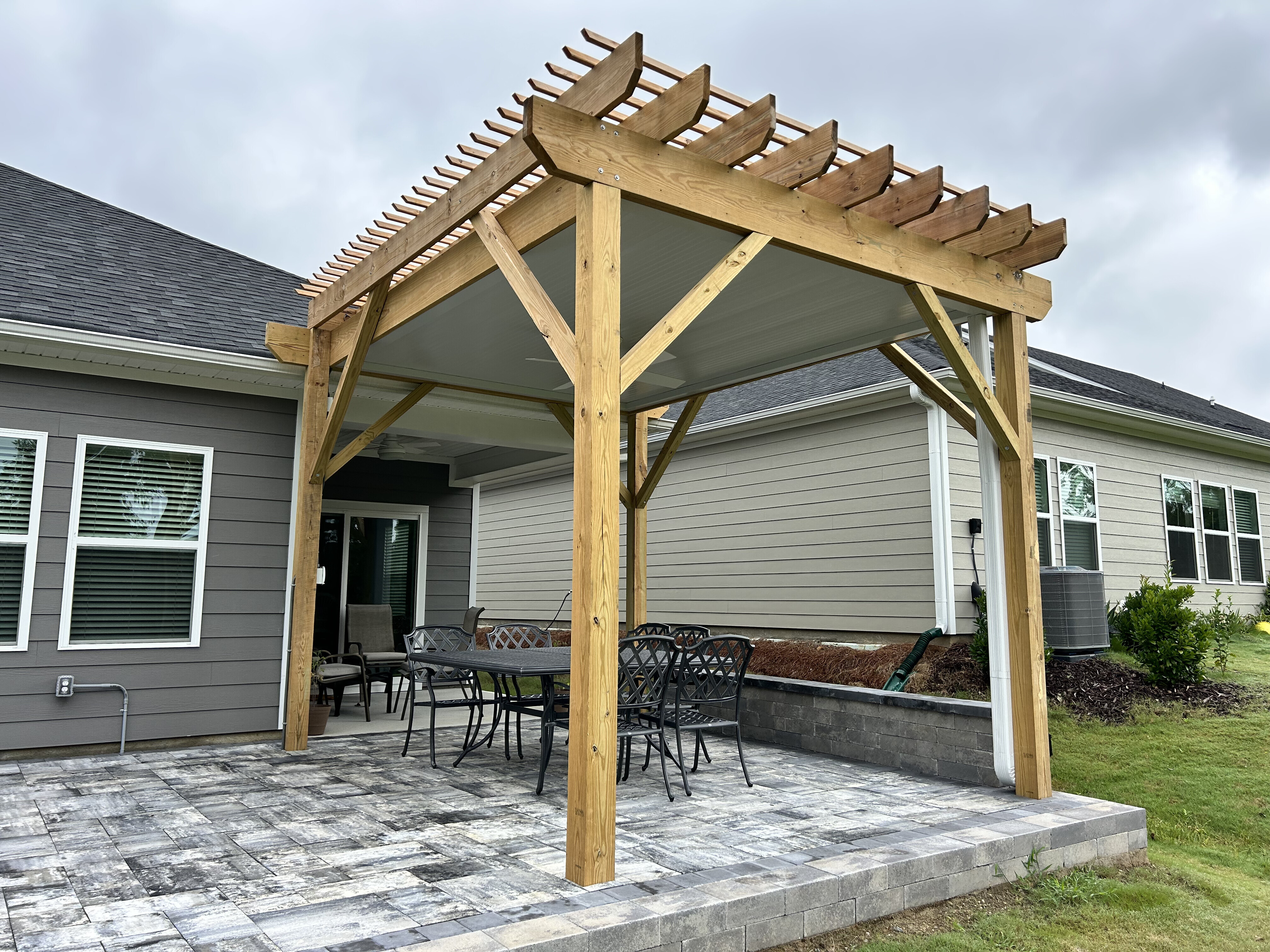 Custom wood pergola with underdeck system over a paver patio.