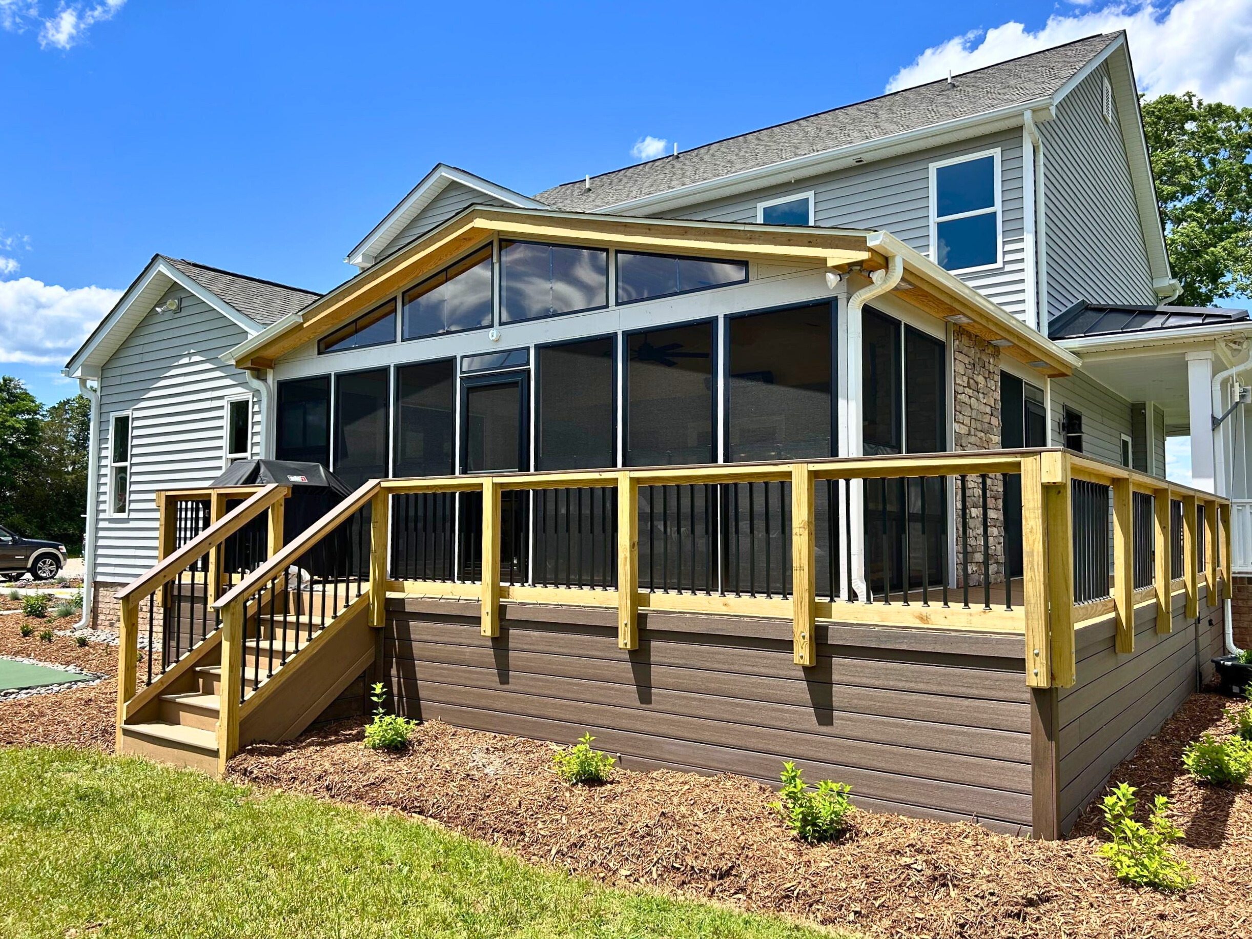 Eze-Breeze porch on a composite deck with wood rails in Charlotte, NC.