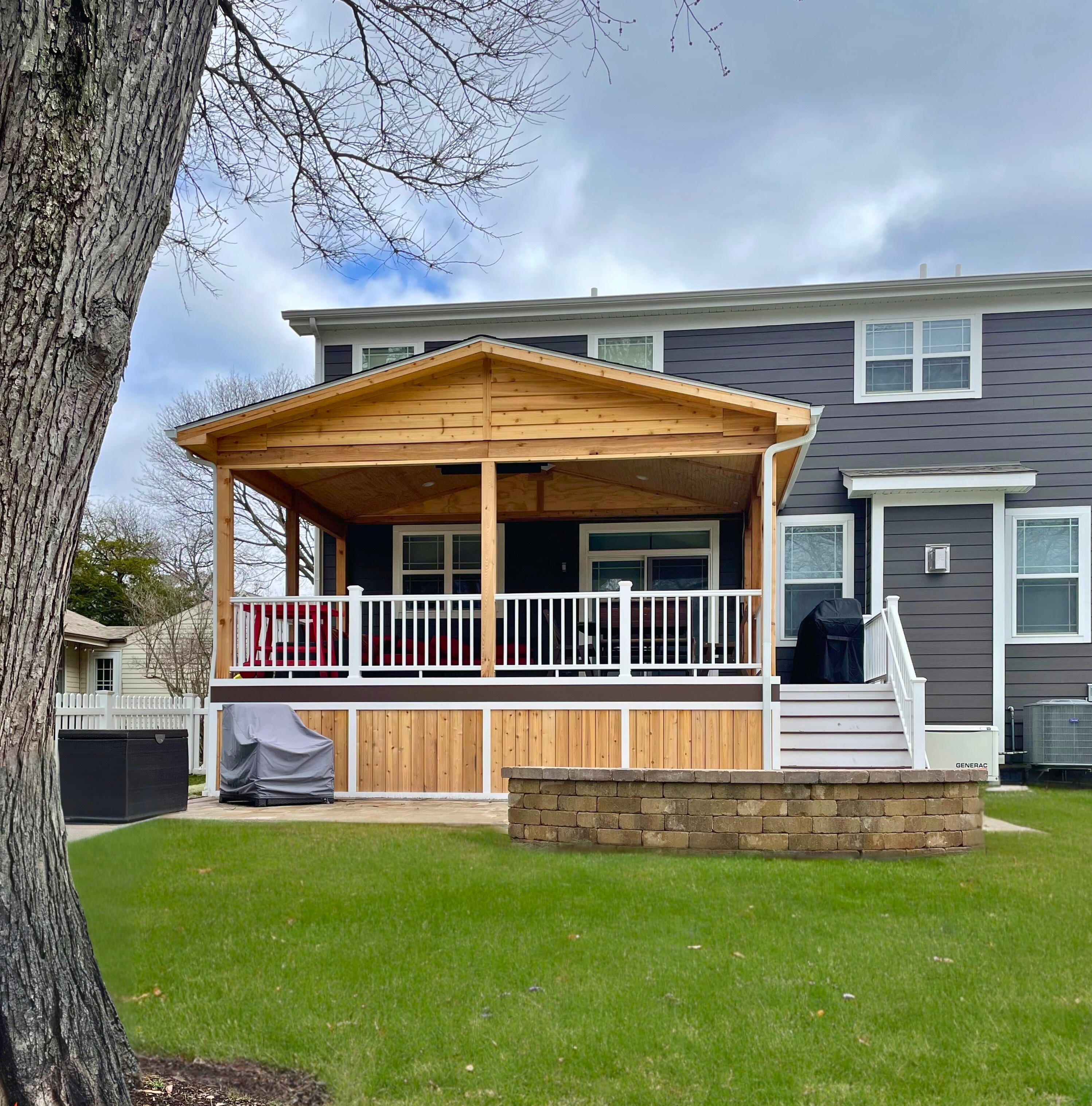 Custom Archadeck porch in Barrington with white rails, open walls, and a paver patio.