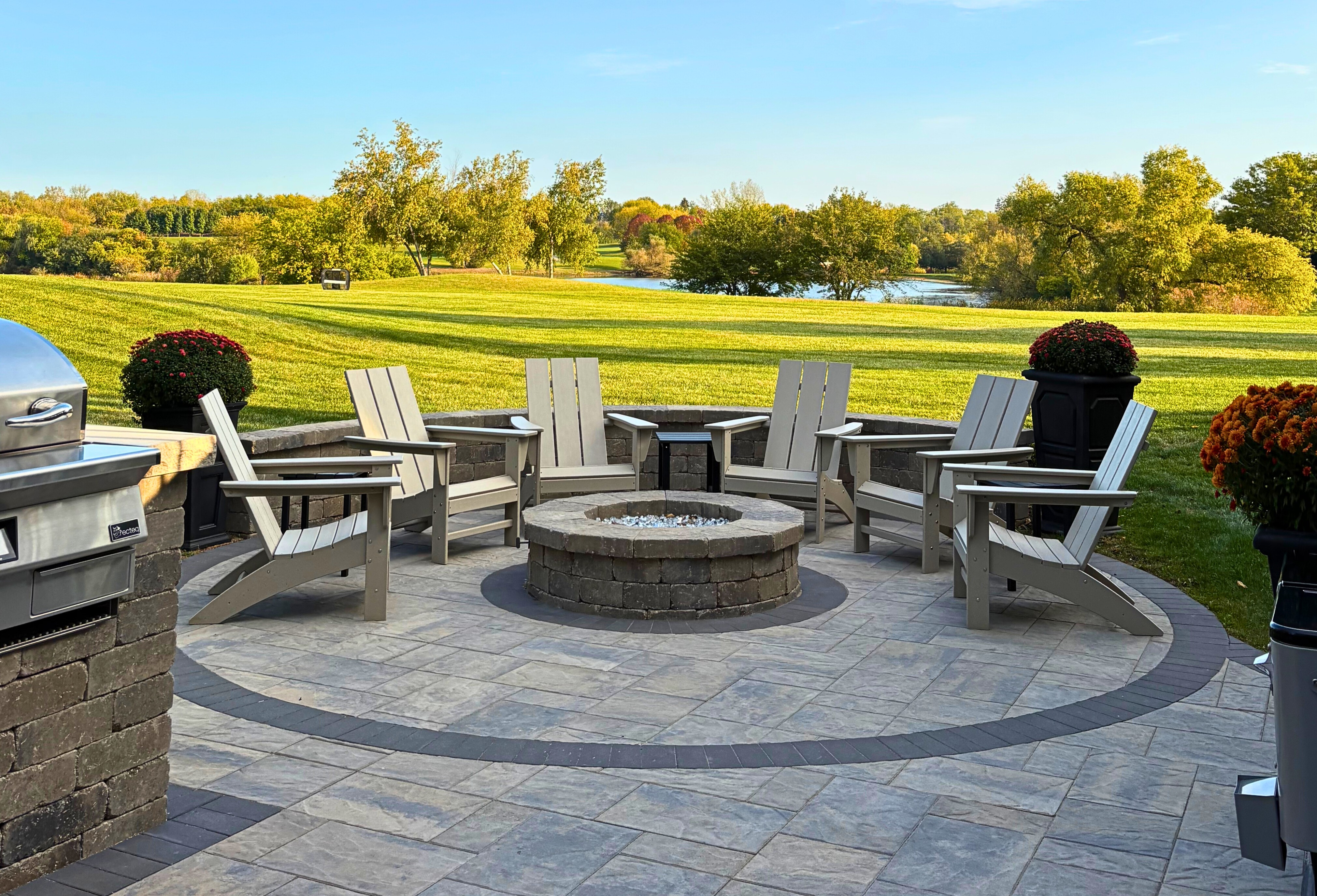 Custom firepit with seat wall and chairs overlooking a stunning golf course in Charlotte,NC.