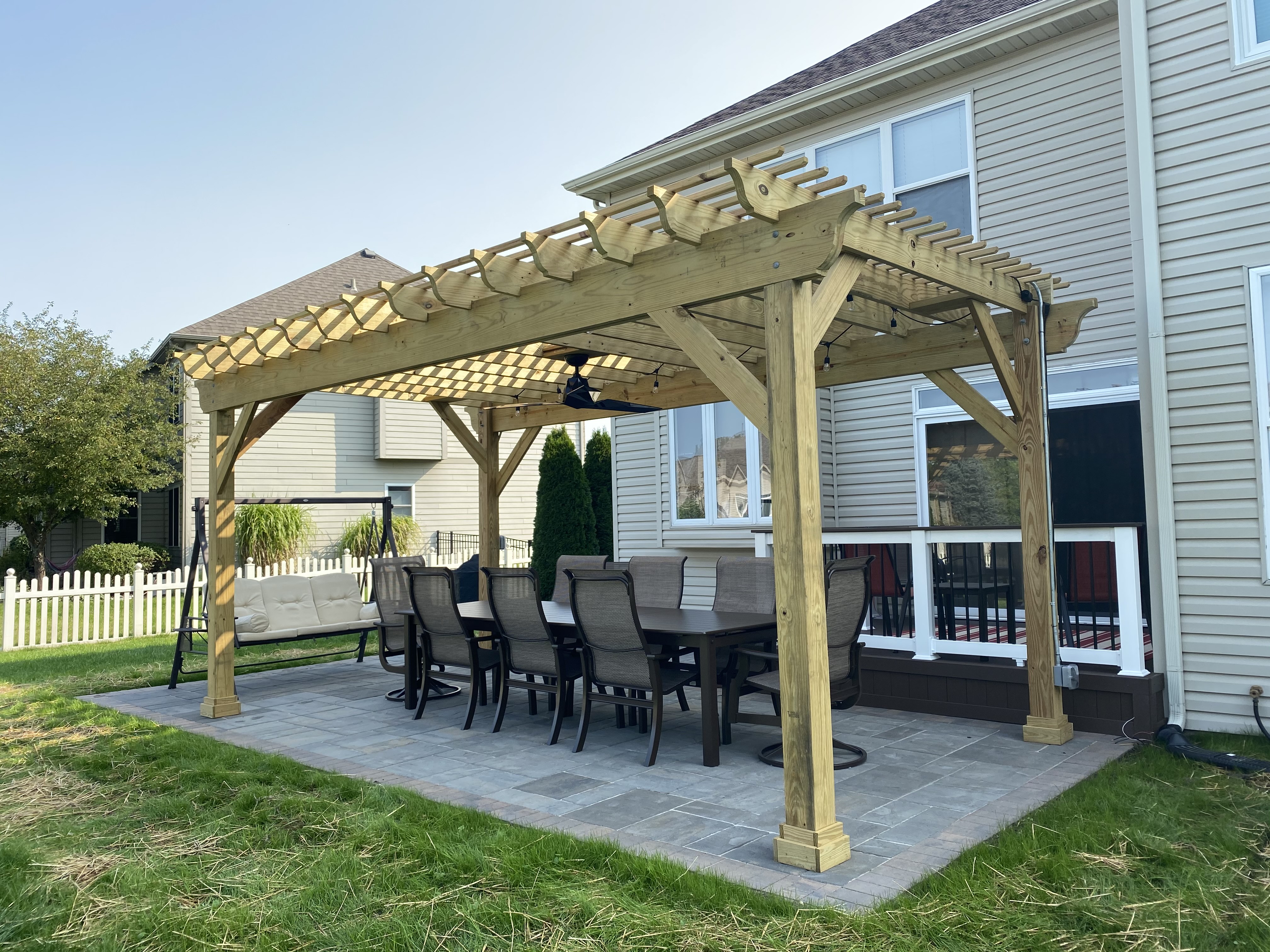 Custom wood pergola over a paver patio and dining set in Naperville, IL.