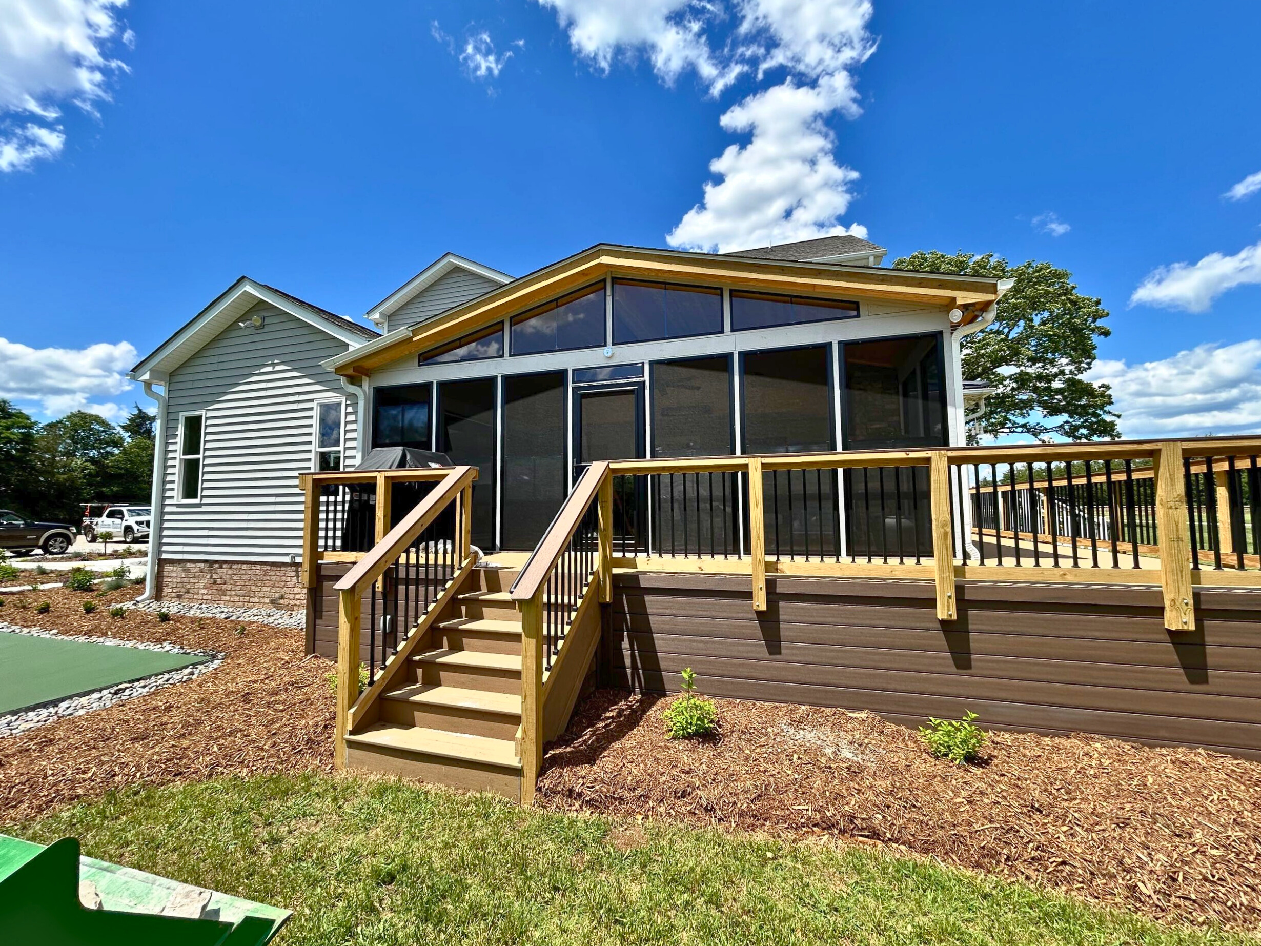 Custom outdoor living space in Matthews, NC with a screened porch and composite deck by Archadeck.