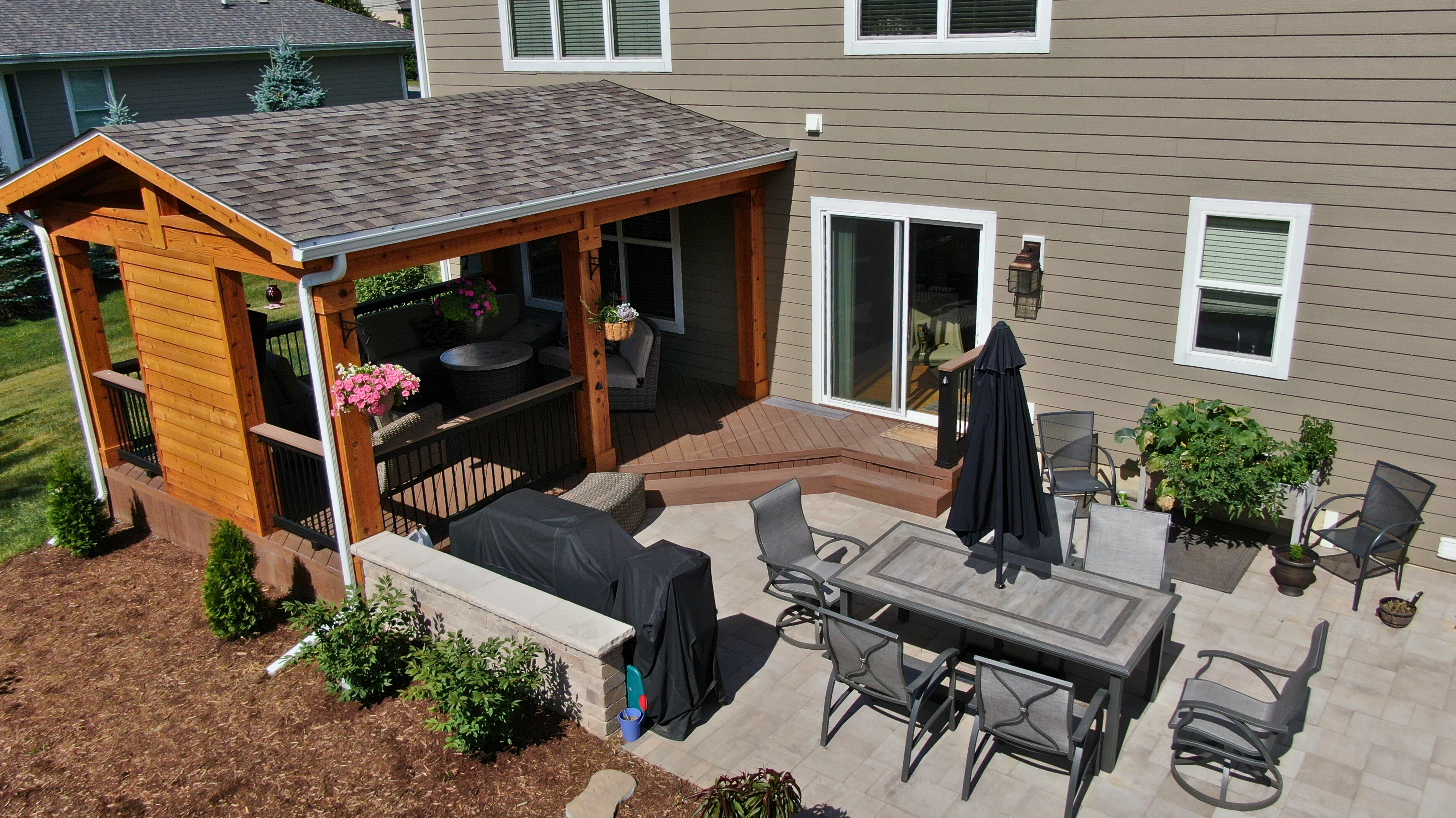 Custom outdoor living space featuring a paver patio and open porch built by Archadeck of Charlotte.