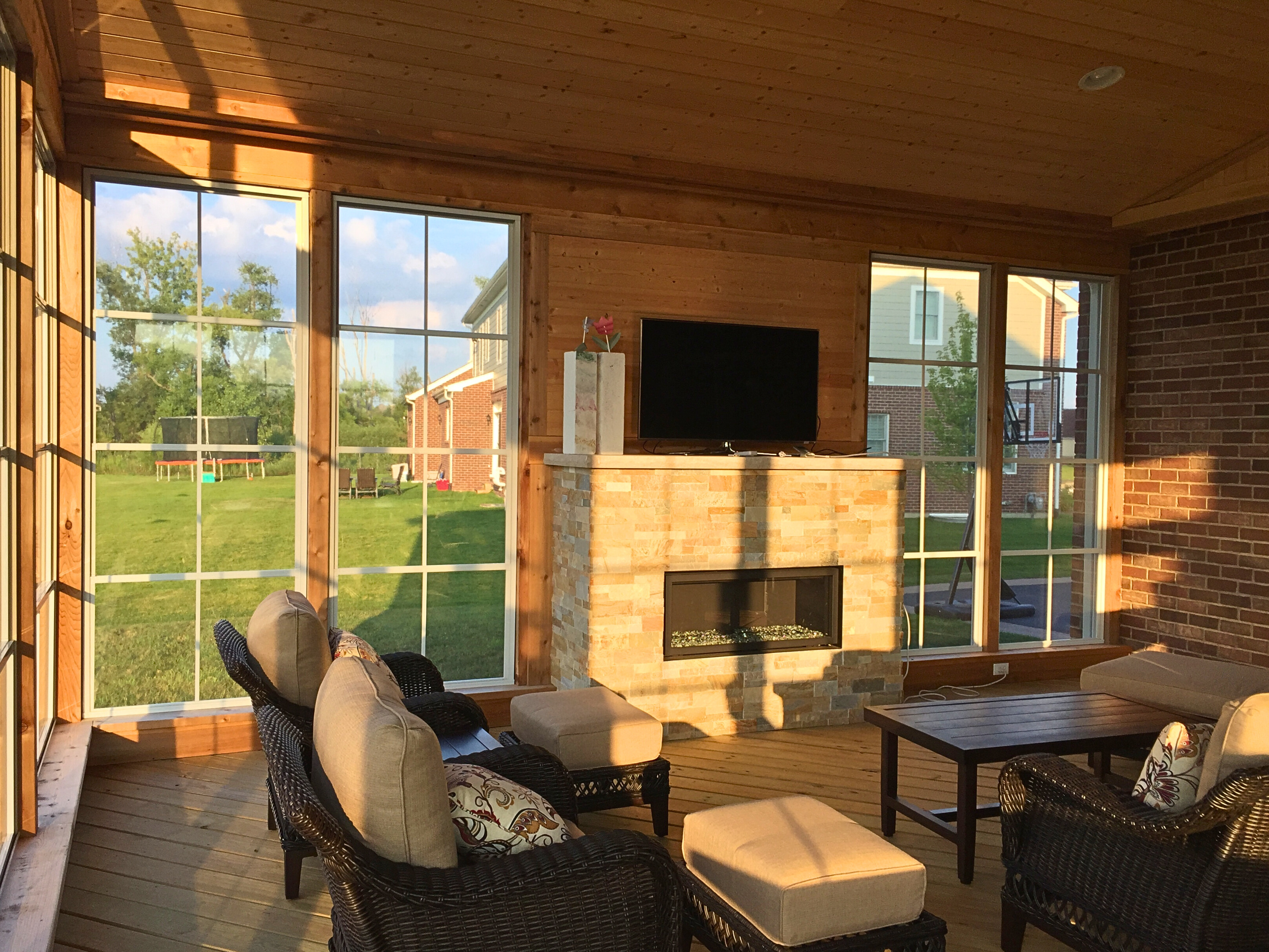 3-season room installed by Archadeck of Naperville with 4-track windows and stone fireplace.