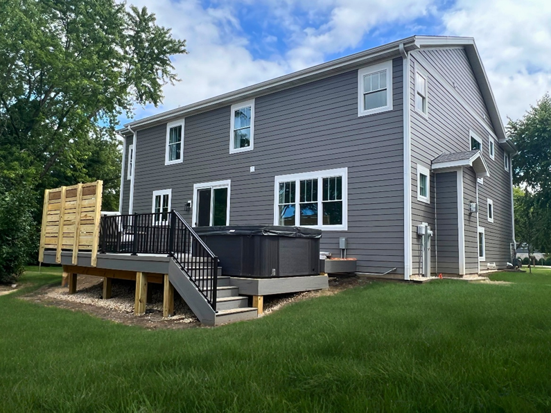 Custom composite deck with privacy fence and hot tub in Arlington Heights, IL backyard.