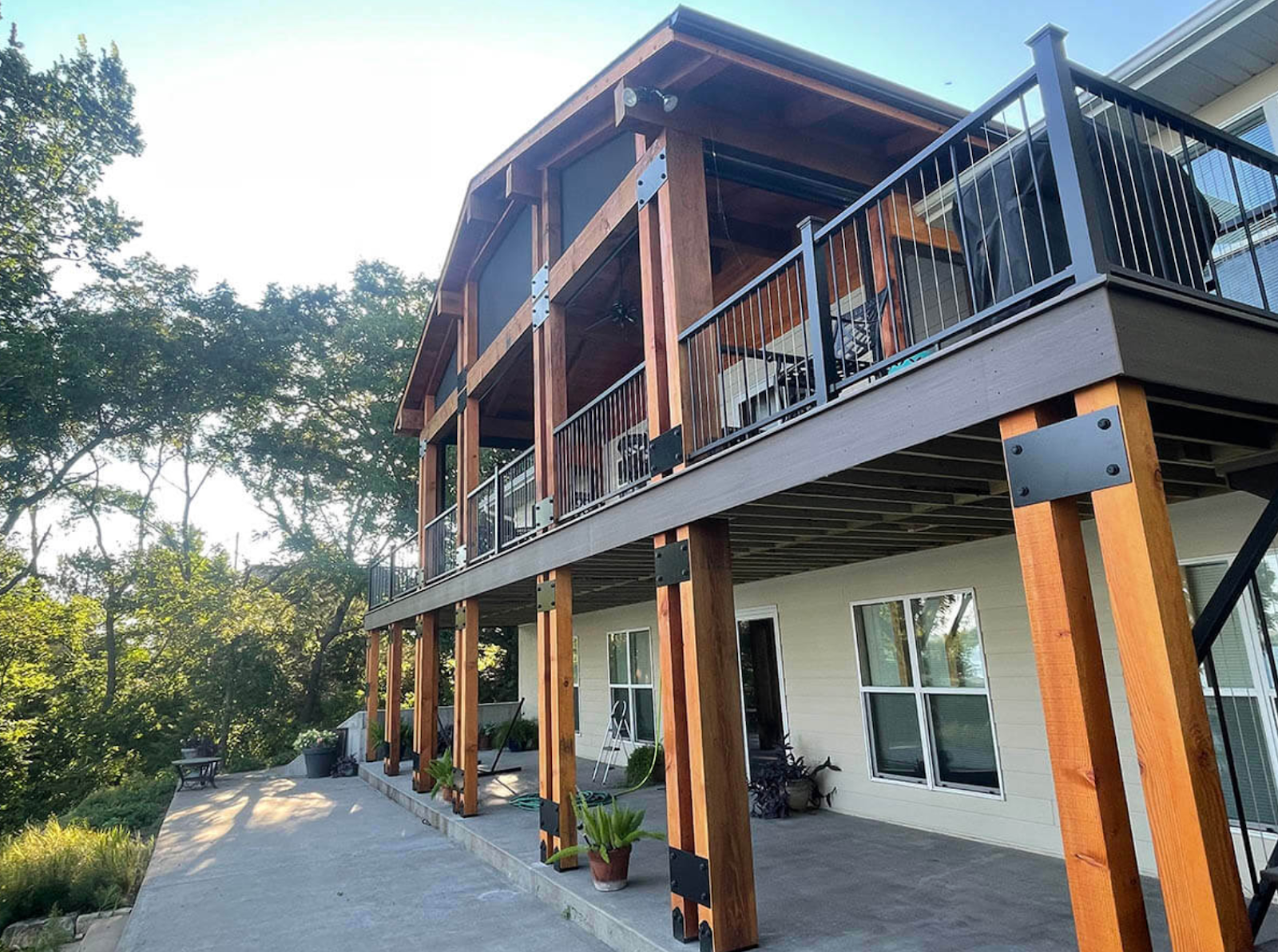 back of a home with wood deck and black railings