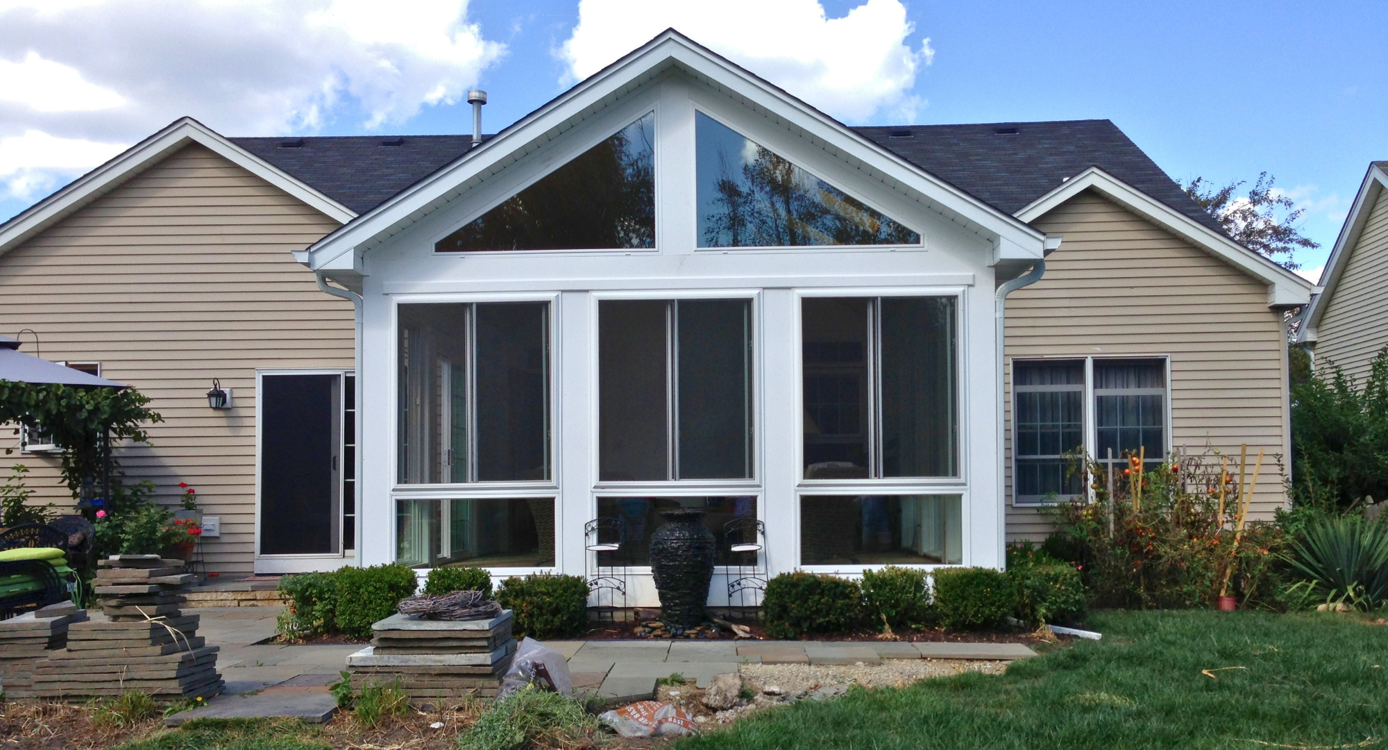 Outside of a custom sunroom with white trim and glass windows in Barrington, IL.