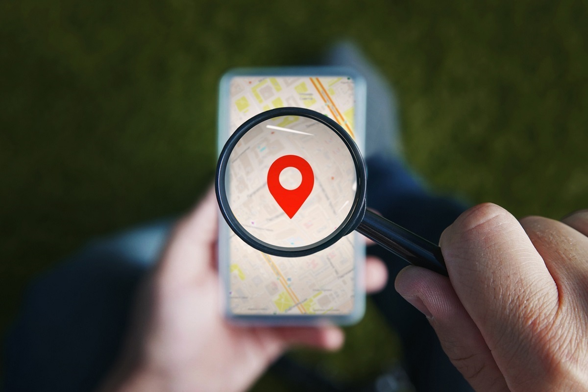 hands holding a phone and magnifying glass