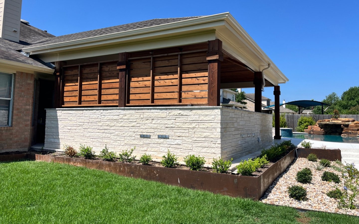 A house with a lawn and a pool
Description automatically generated