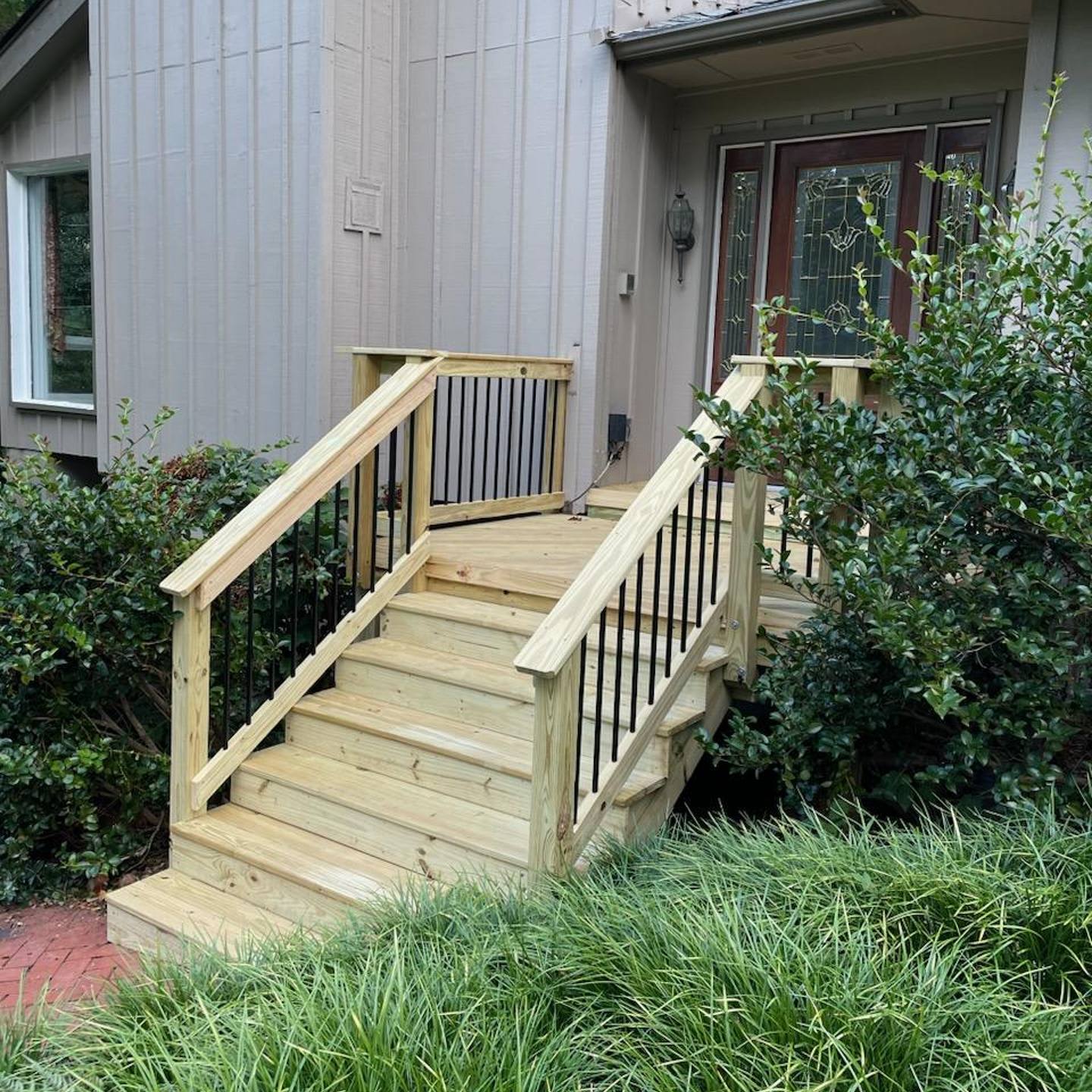 A wooden stairs leading to a house
Description automatically generated