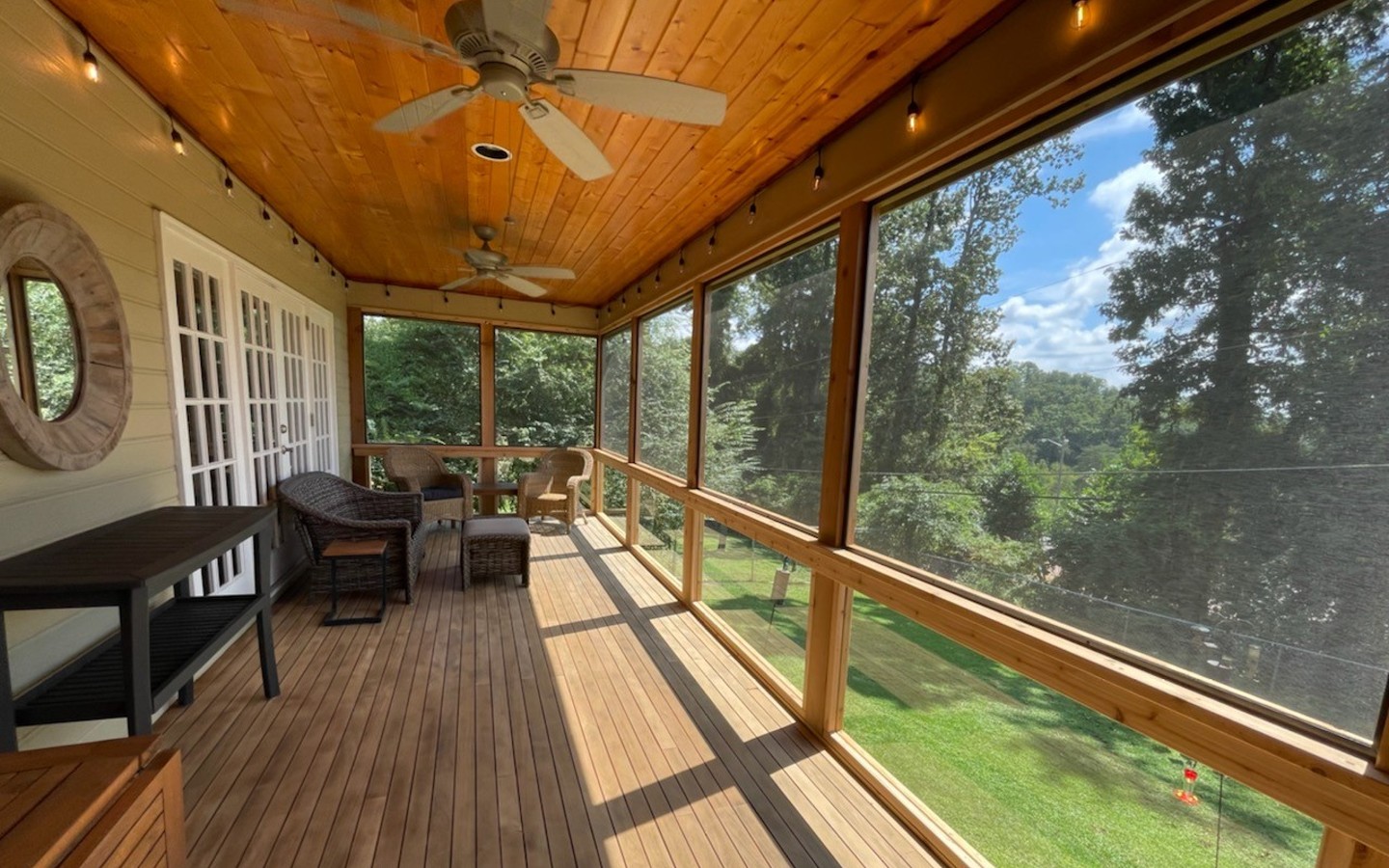 A porch with a ceiling fan and a table
Description automatically generated