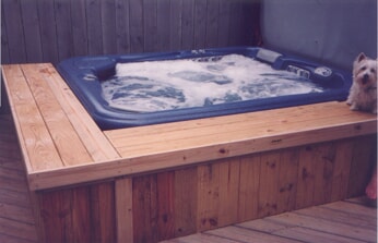 hot tub with wood built in on deck