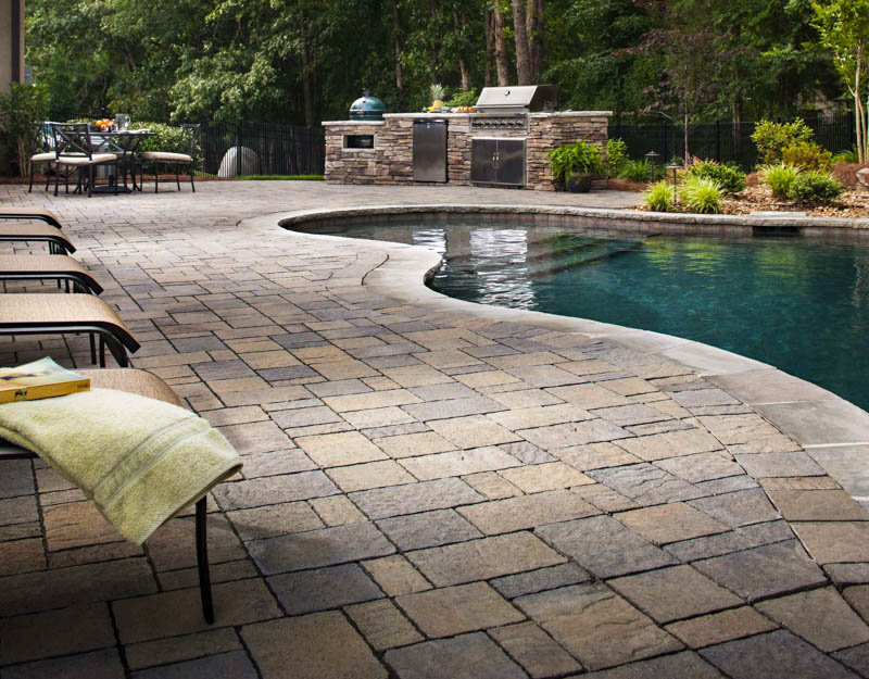 stone patio with pool and outdoor kitchen