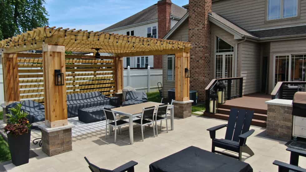 Outdoor living space with a paver patio, composite deck, and cedar pergola with pillars and thick columns in Barrington, IL.
