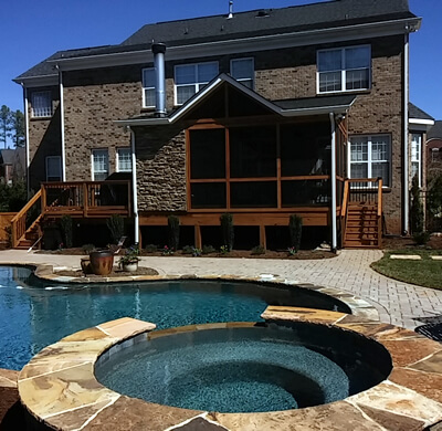 screened porch overlooking a paver patio and pool in marvin nc