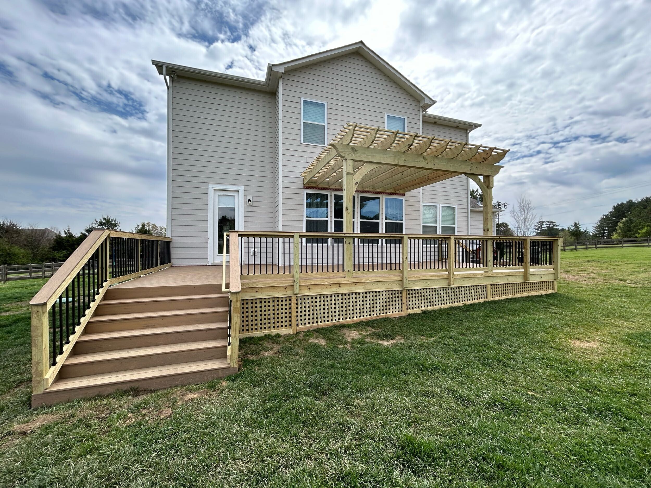 Large composite deck and wooden pergola combination built by Archadeck in Indian Land, SC, enhancing backyard usability.
