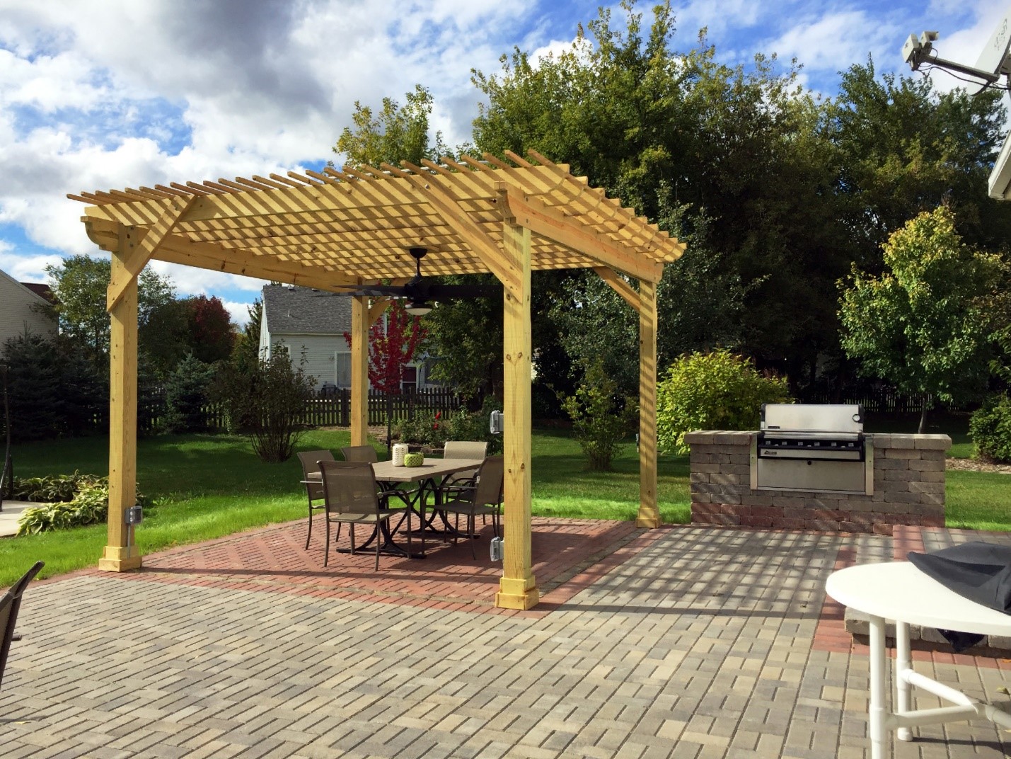 Wood pergola design over a paver patio and outdoor kitchen in Naperville, IL.