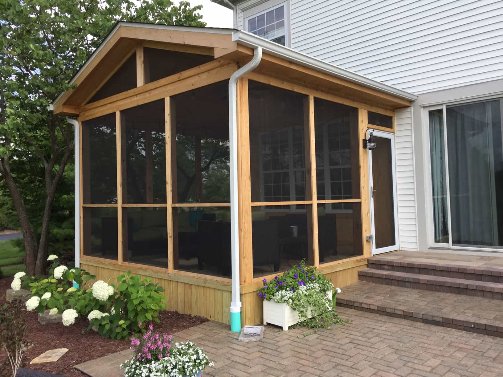 Exterior view of a paver patio and screened porch in St. Charles, IL.