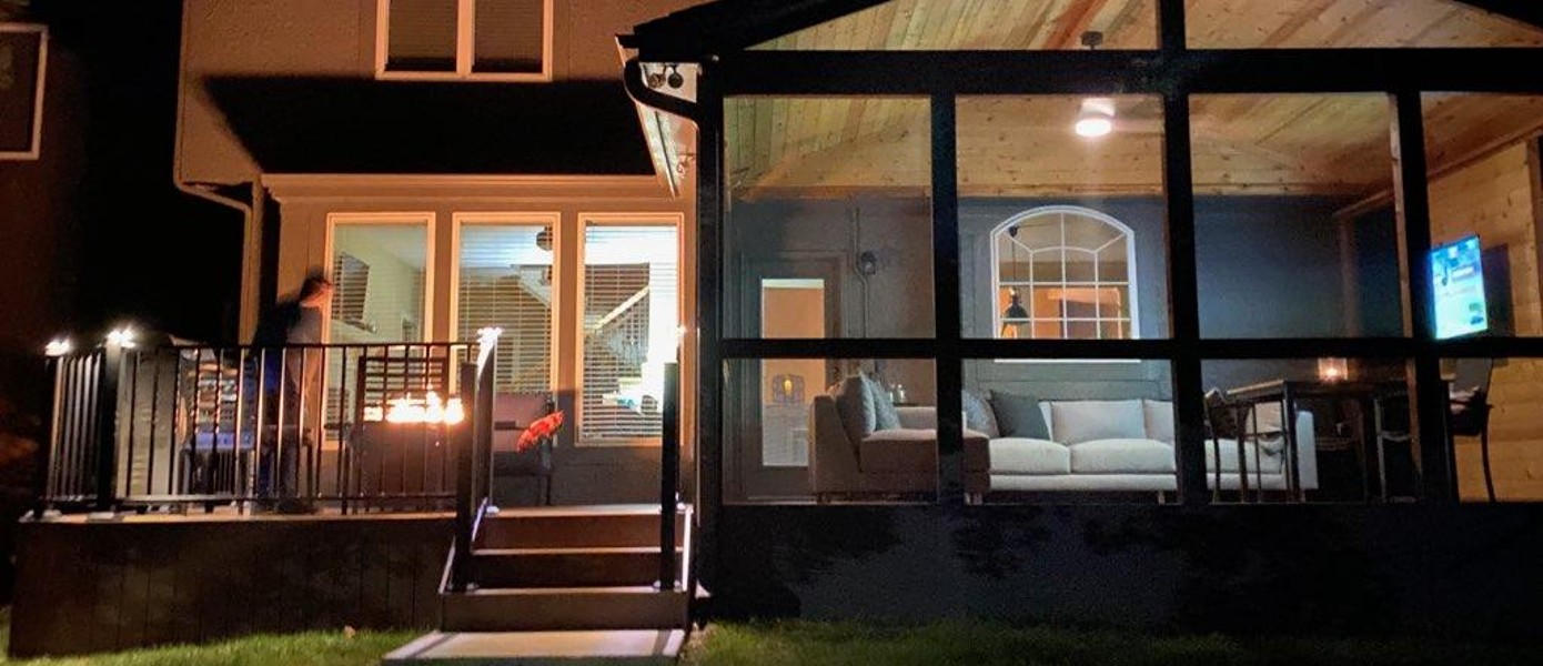 Screened porch connected to patio with fire pit.