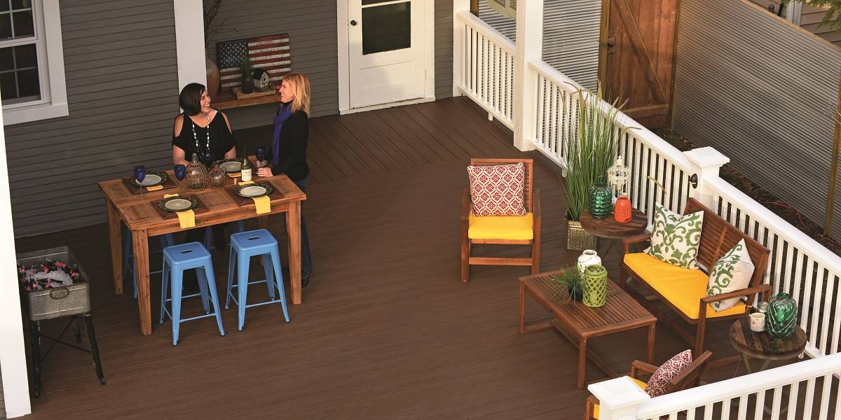 Two women standing by dinner table out on deck