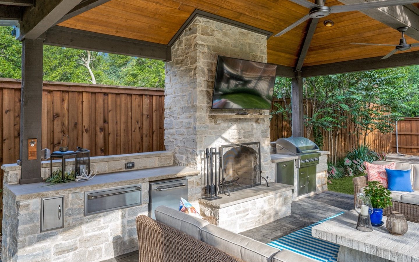 A patio with a fireplace and a television
Description automatically generated