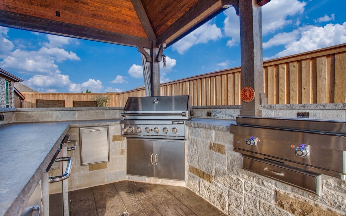 A outdoor kitchen with a wood deck
Description automatically generated with medium confidence