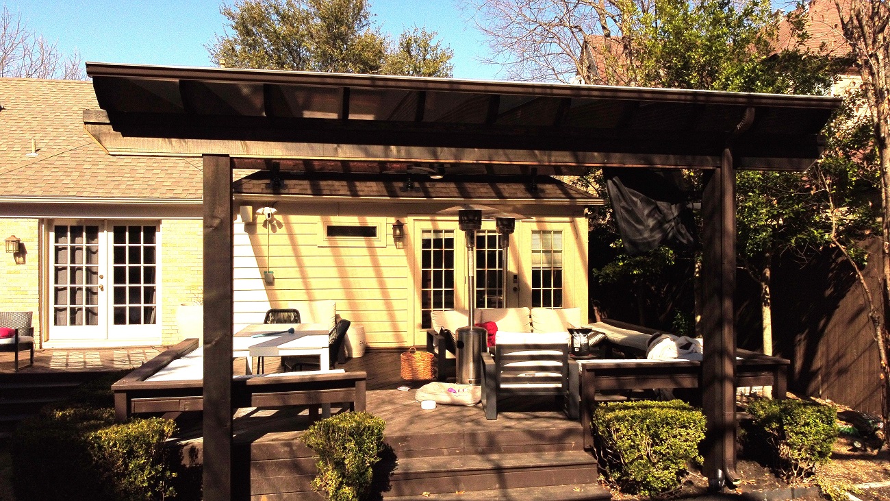 A sloped roof translucent pergola provides an incredible outdoor space.