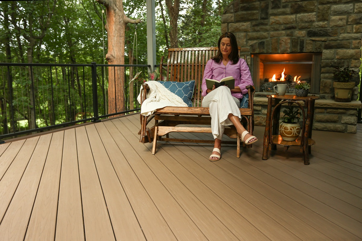 woman reading on her covered porch next to fireplace