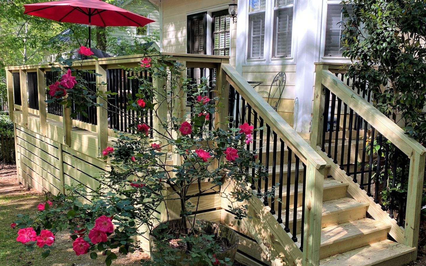 A deck with stairs and a red umbrella

AI-generated content may be incorrect.