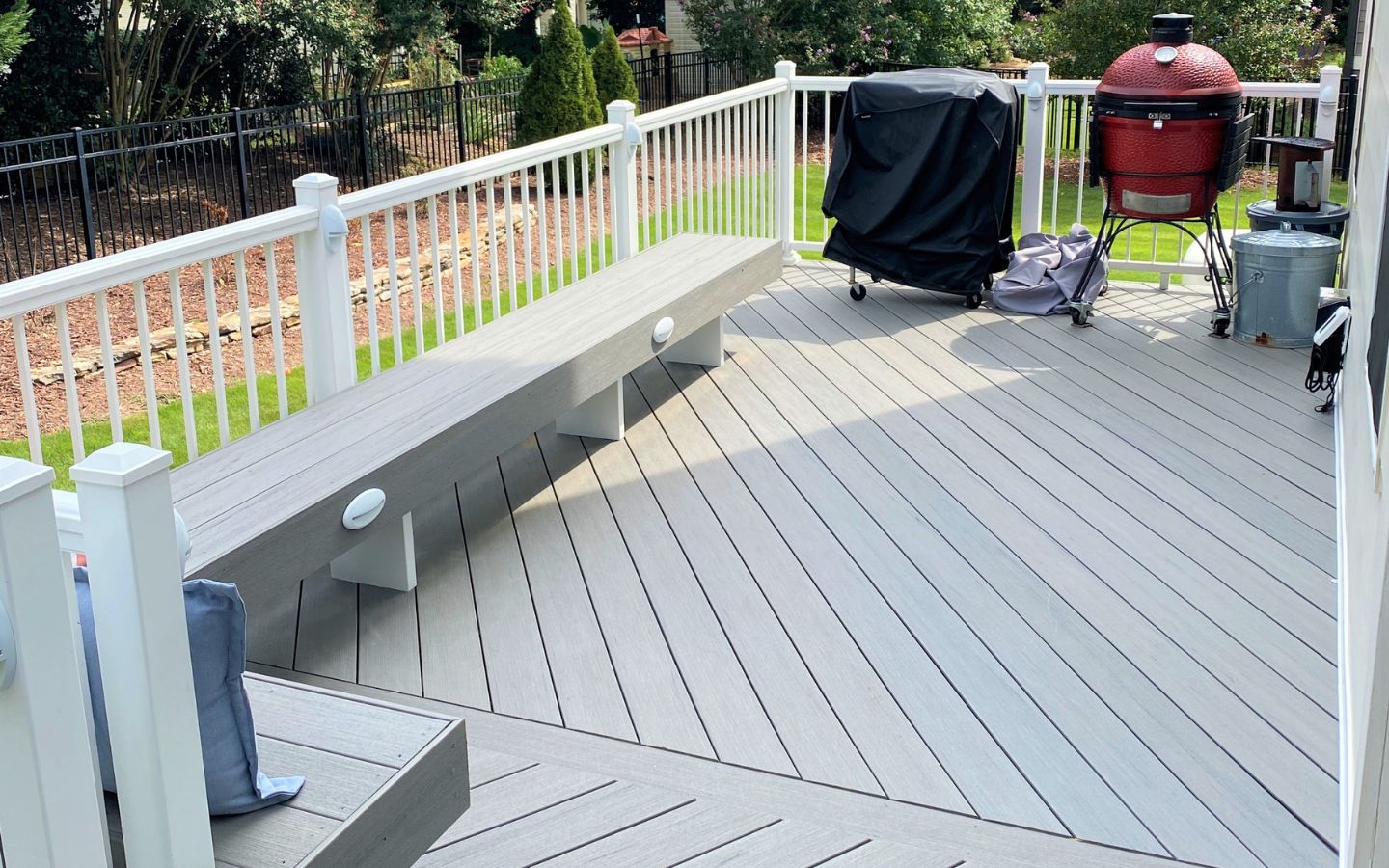 A wooden deck with a white railing and a bench

AI-generated content may be incorrect.