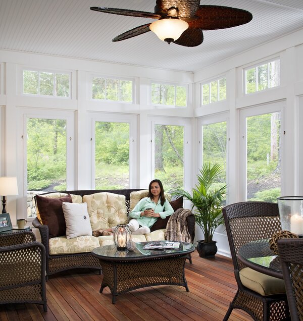 Woman sittign in screened in patio holding a coffee