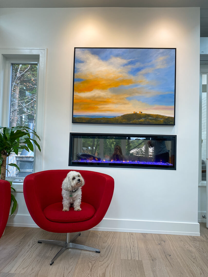 dog sitting on chair next to fireplace in sunroom